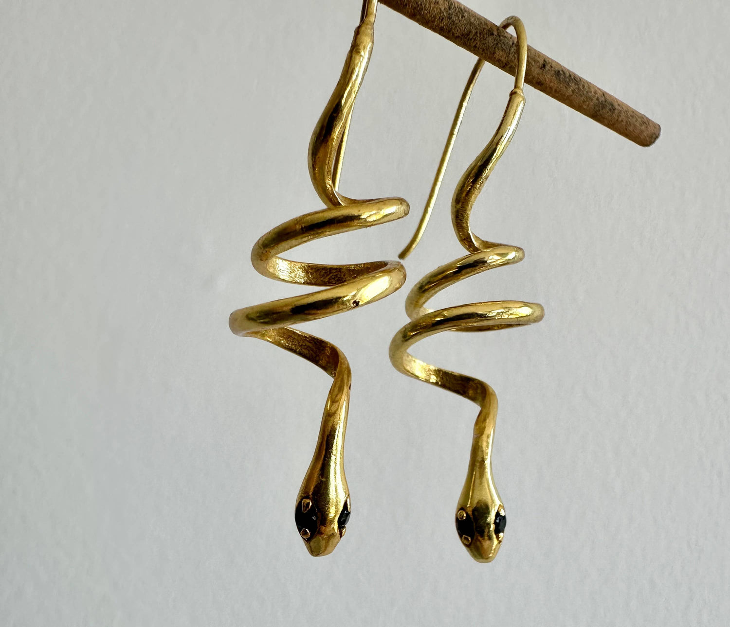 Gold snake earrings with green zircon eyes by Anokhi Green
